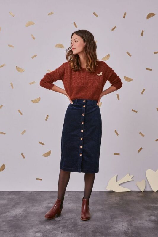 Outfit con falda corta azul marino y sweater verde para otono