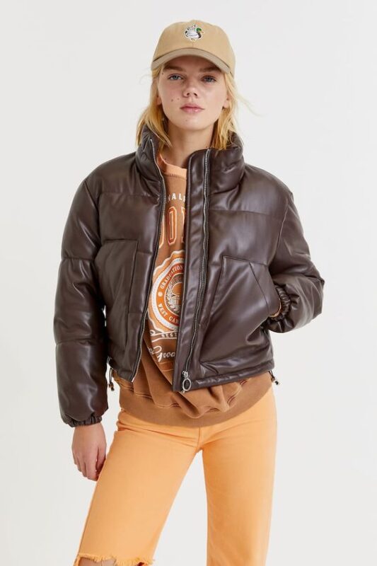 Outfit con puffer marron oscuro para invierno y pantalon naranja