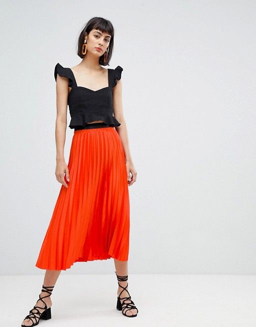falda naranja con blusa negra